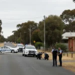 New South Wales Police officers and emergency vehicles at a crime scene in Lake Cargelligo following a fatal shooting.